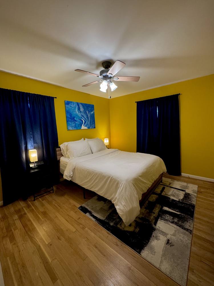 Bedroom with a freshly made bed and navy curtains